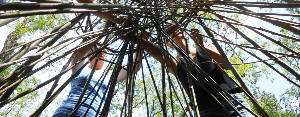 Menschen bauen ein Zelt aus Weideästen in der Natur